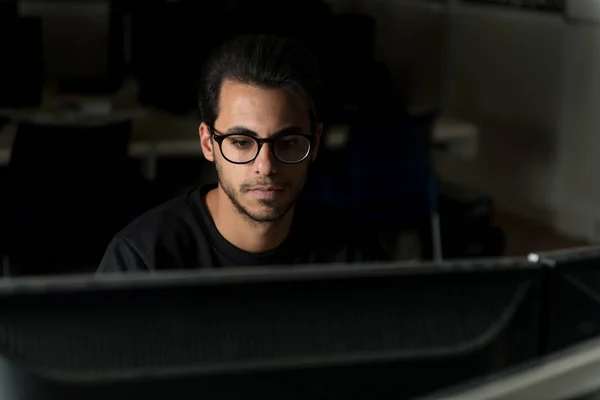 Veja sobre uma tela do rosto de um jovem estudante de ciência da computação que trabalha com o computador . — Fotografia de Stock