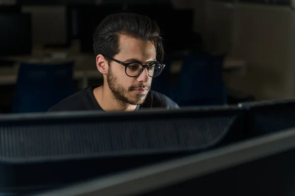 Veja sobre uma tela do rosto de um jovem estudante de ciência da computação que trabalha com o computador . — Fotografia de Stock