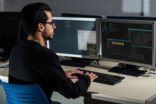Young computer science student developing with his computer on a Linux System over double screen system — Stock Photo, Image