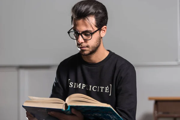 Jonge computer science student leest een geavanceerde robotica boek in Caceres, Spanje. — Stockfoto