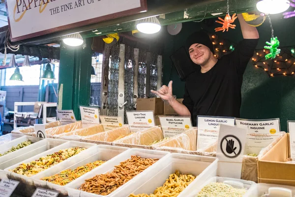 Een jonge verkoper poseert op een Italiaanse pasta stand op Pike Market in Seattle, Washington, USA. — Stockfoto