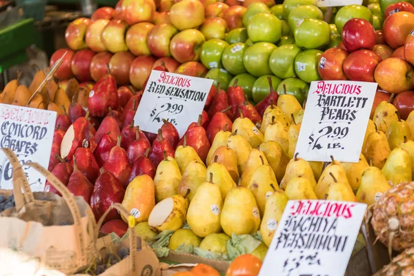 Kleurrijke en gevarieerde peren en appels op een kraam op Pike Place Market in Seattle. — Stockfoto