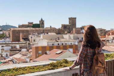 Bir sırt çantası ile genç bir kızıl saçlı turist Galarza bakış açısıyla Caceres eski kenti gözlemleriyle