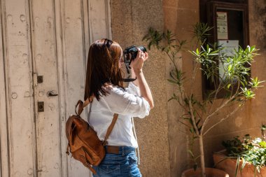 Bir sırt çantası ile genç Kızıl saçlı turist Caceres eski kent dar sokakları fotoğrafları alır