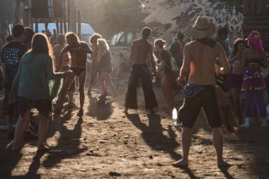 Kayıp Teori psytransce müzik festivalinin ana sahnesinde gün batımında dans eden insanların siluetleri