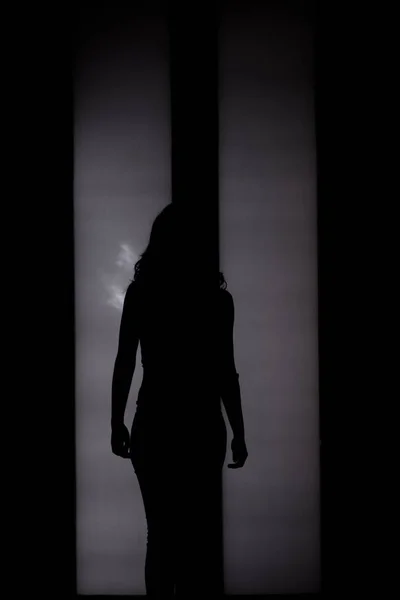 Silueta de mujer delante de la puerta trasera iluminada — Foto de Stock