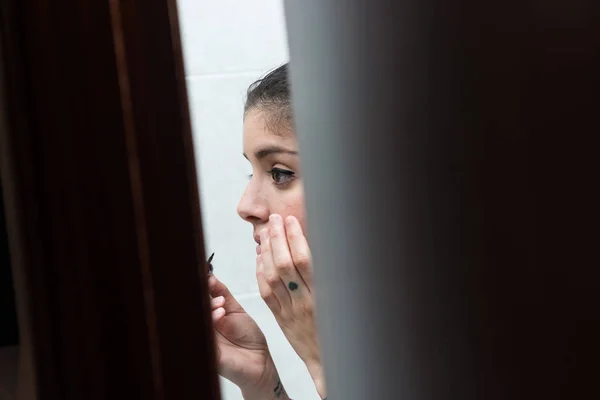 Молодая девушка придумывает вид через дверь ванной комнаты . — стоковое фото