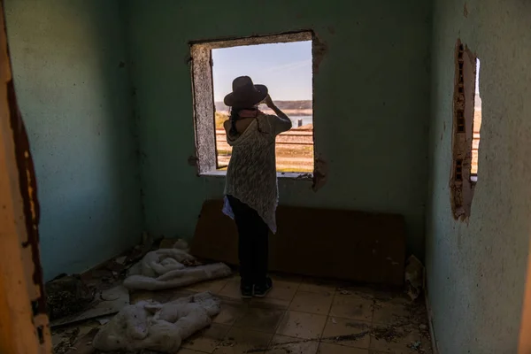 Een vrouw neemt Foto's met haar Smartphone door het raam van een verlaten huis in de buurt van Garrovillas de Alconetar — Stockfoto