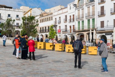 Asyalı turistlerin bir grup Plaza Mayor Caceres mektupları ile taş işareti yanında fotoğraf çekmek