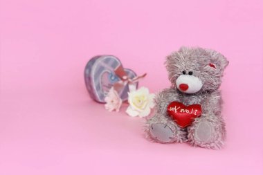 Sevgililer günü için pembe arka plan üzerinde çiçekli gri oyuncak ayı