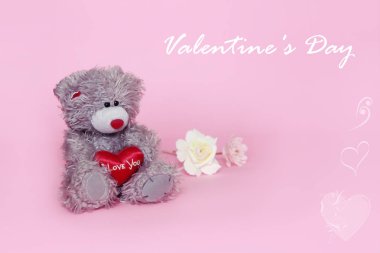 Sevgililer günü için pembe arka plan üzerinde çiçekli gri oyuncak ayı