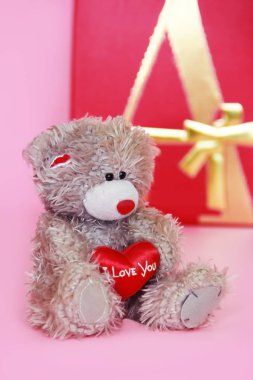 Dekoratif gri oyuncak ayı Tatil Sevgililer günü için pembe arka plan üzerinde