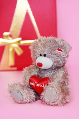 Dekoratif gri oyuncak ayı Tatil Sevgililer günü için pembe arka plan üzerinde