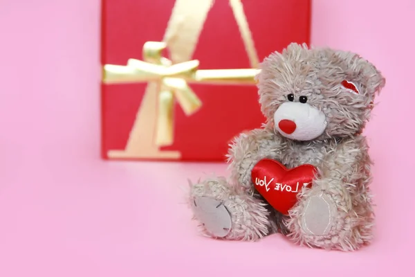 decorative gray teddy bear on pink background for the holiday Valentine\'s Day