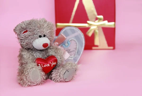 decorative gray teddy bear on pink background for the holiday Valentine's Day