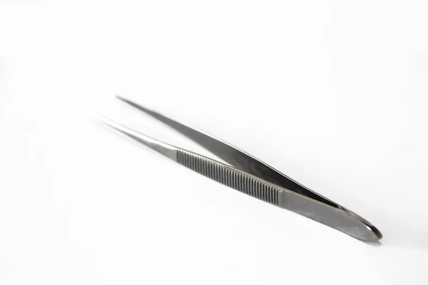 Gray metallic sharp tweezers on  white background — Stock Photo, Image