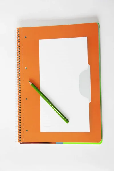 Groene student gel pen op een achtergrond van Orange notebook — Stockfoto