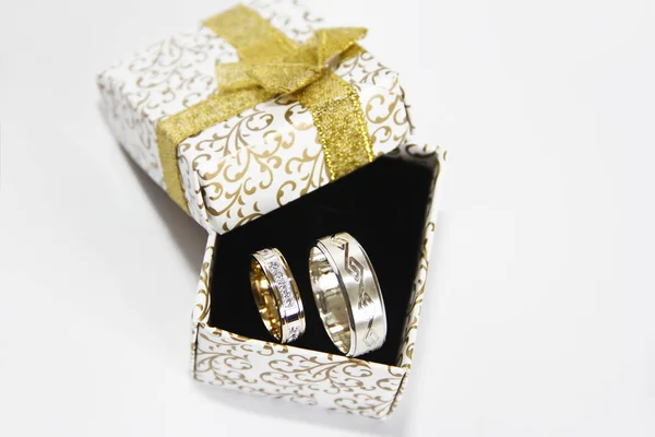 Gold silver wedding rings in a gift box on a black background — Stock Photo, Image