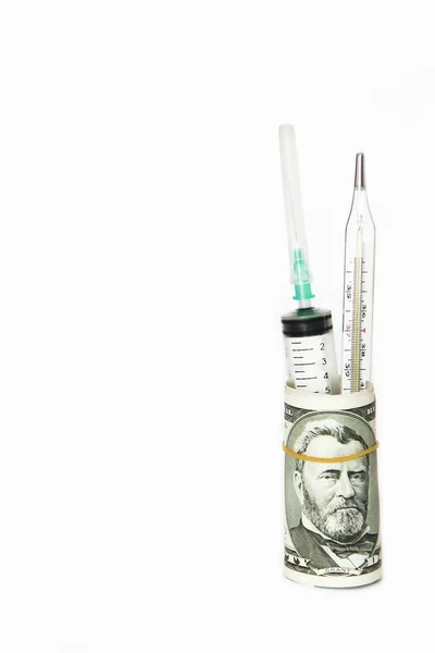Jeringa médica y termómetro en un rollo de dólares sobre un fondo blanco —  Fotos de Stock