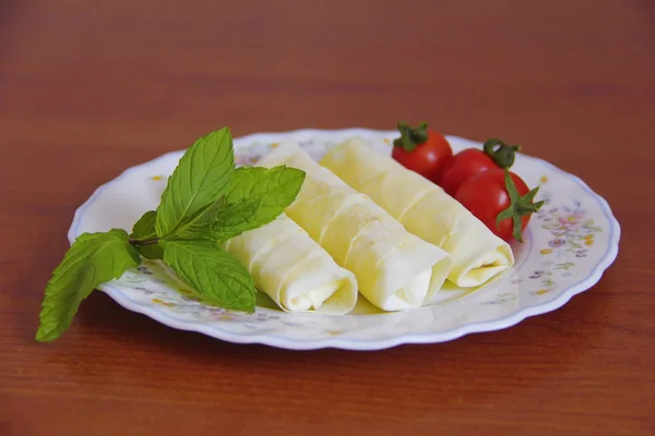 Турецкие пироги, помидоры и листья мяты на тарелке — стоковое фото