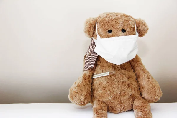 Kahverengi yumuşak oyuncak ayı burnunda bir bandaj ve tıbbi bir termometre ile hasta — Stok fotoğraf