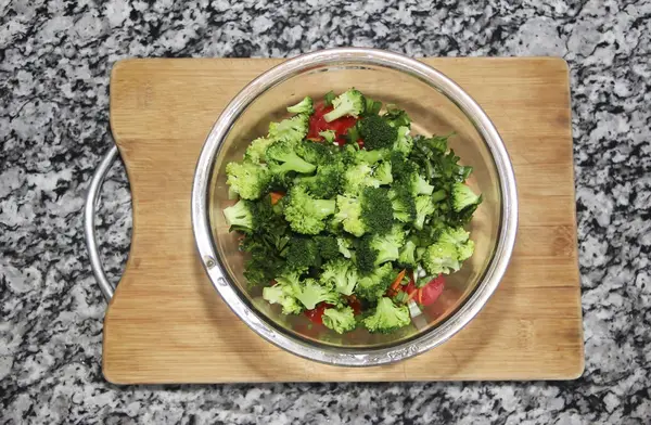 Salada de brócolis verde em uma placa de vidro em um fundo de madeira — Fotografia de Stock