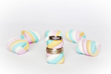 çok renkli marshmallow bir arka plan üzerinde alyans altın yüzük