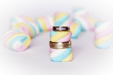 çok renkli marshmallow bir arka plan üzerinde alyans altın yüzük