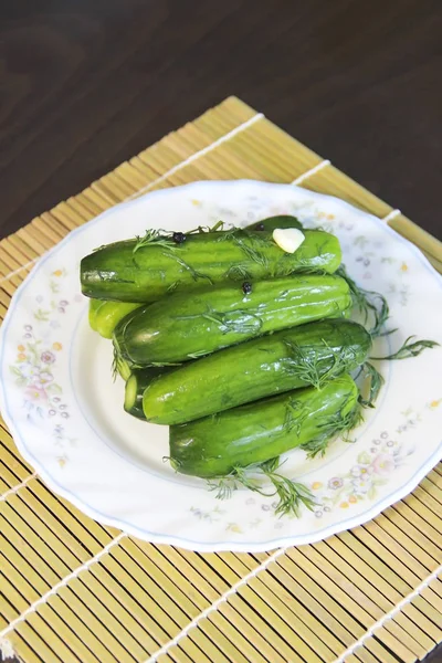 Nasolené zelené okurky s Dill a ochucení na bílé desce — Stock fotografie