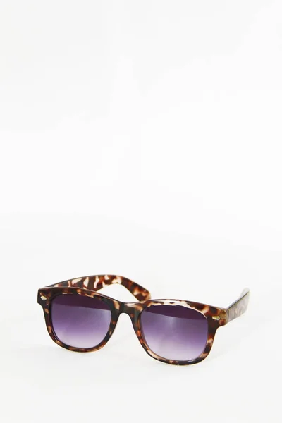 Óculos de sol em uma moldura de plástico marrom e lentes roxas em um fundo branco — Fotografia de Stock