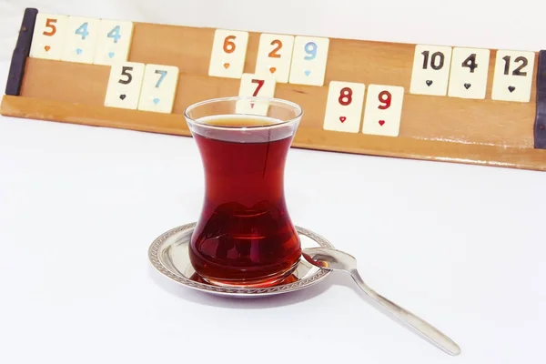 Thé turc dans une tasse en verre sur le fond d'un jeu de table turc okey — Photo