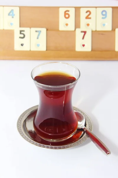 Turkish tea in a glass cup on the background of a Turkish table game okey