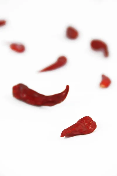 Pods van rood gedroogde hete bittere eetbare peper op een witte achtergrond — Stockfoto