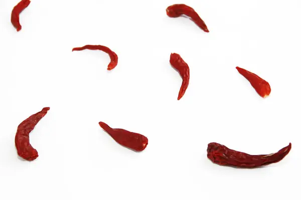 Vagens de pimentão comestível quente amargo seco vermelho em um fundo branco — Fotografia de Stock
