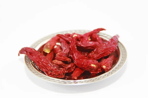 Pods of dried red hot edible pepper in a metal plate on a white background — Stock Photo, Image