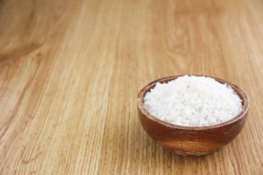 sarı arka plan üzerinde kahverengi ahşap plaka doğal beyaz pirinç