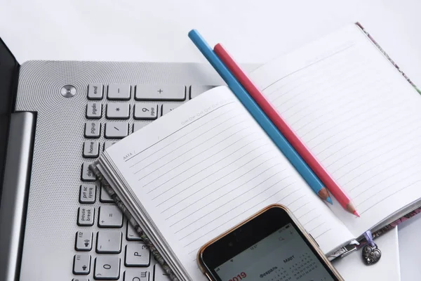 Notebook dla firm z białymi arkuszami i ołówki na tle klawiatury komputerowej i telefonu — Zdjęcie stockowe