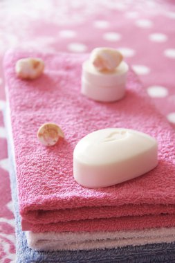 pembe havlu arka planına karşı beyaz tuvalet sabun ve dekor