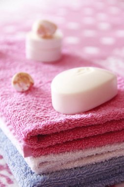 pembe havlu arka planına karşı beyaz tuvalet sabun ve dekor