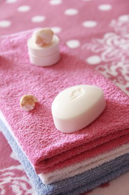 pembe havlu arka planına karşı beyaz tuvalet sabun ve dekor