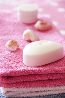 pembe havlu arka planına karşı beyaz tuvalet sabun ve dekor