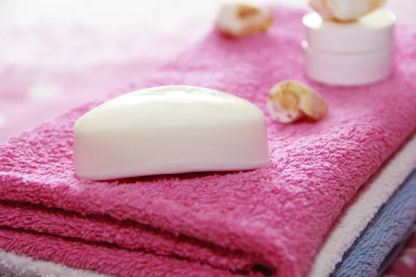 pembe havlu arka planına karşı beyaz tuvalet sabun ve dekor