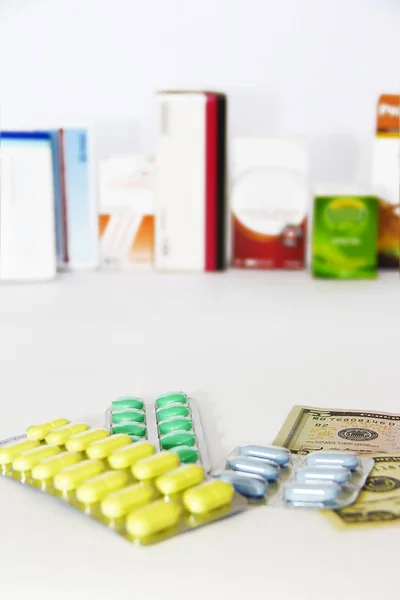 Желтый зеленый синий медицинских таблеток и американских долларов на белом фоне — стоковое фото