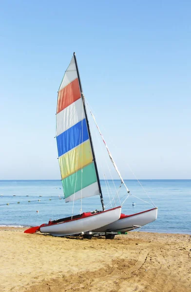 Plachetnici s vícebarevným praporkem na pozadí modrého moře — Stock fotografie