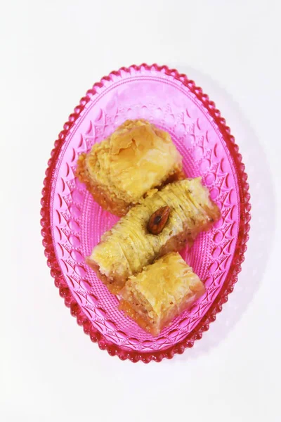 traditional Turkish sweet baklava with nuts in a pink decorative plate