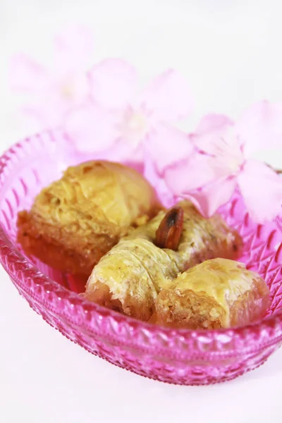 traditional Turkish sweet baklava with nuts in a pink decorative plate
