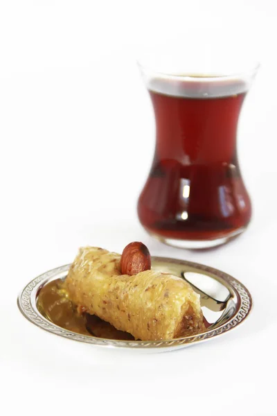 Dulce tradicional turco con nueces de baklava y té turco en un vaso de precipitados — Foto de Stock