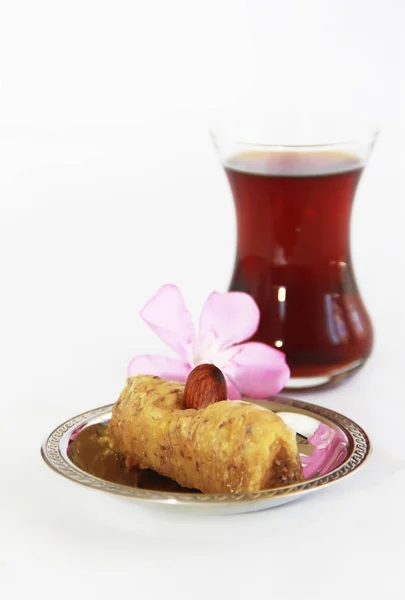 Dulce tradicional turco con nueces de baklava y té turco en un vaso de precipitados — Foto de Stock
