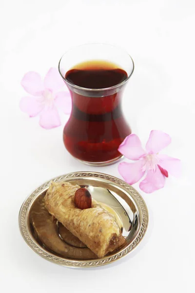 Dulce tradicional turco con nueces de baklava y té turco en un vaso de precipitados — Foto de Stock