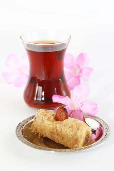 Dulce tradicional turco con nueces de baklava y té turco en un vaso de precipitados — Foto de Stock